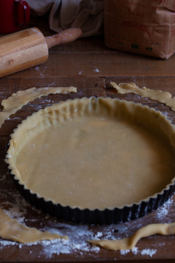 Shortcrust pastry in tart tin with egdes trimmed off.