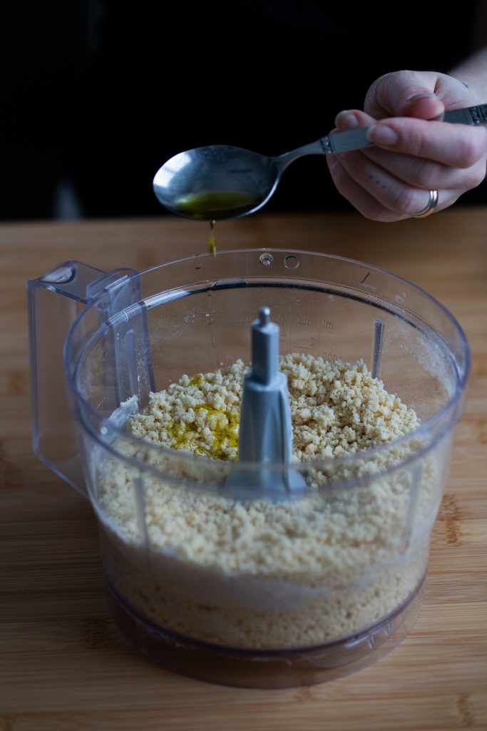 Making fresh pasta in the food processor: adding olive oil.