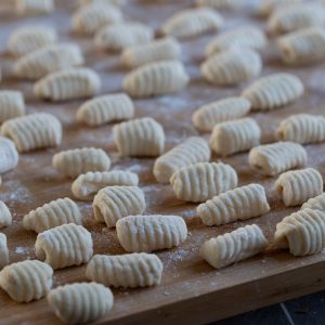 Uncooked ricotta gnocchi on a floured surface.