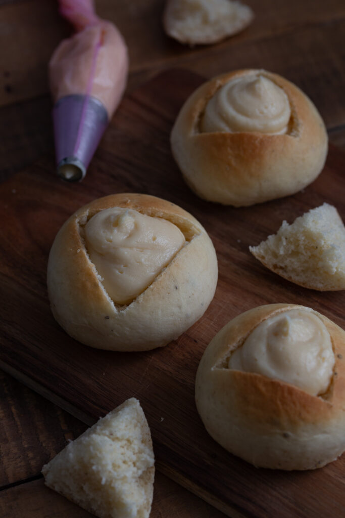 Filling sweet buns with vanilla cream.