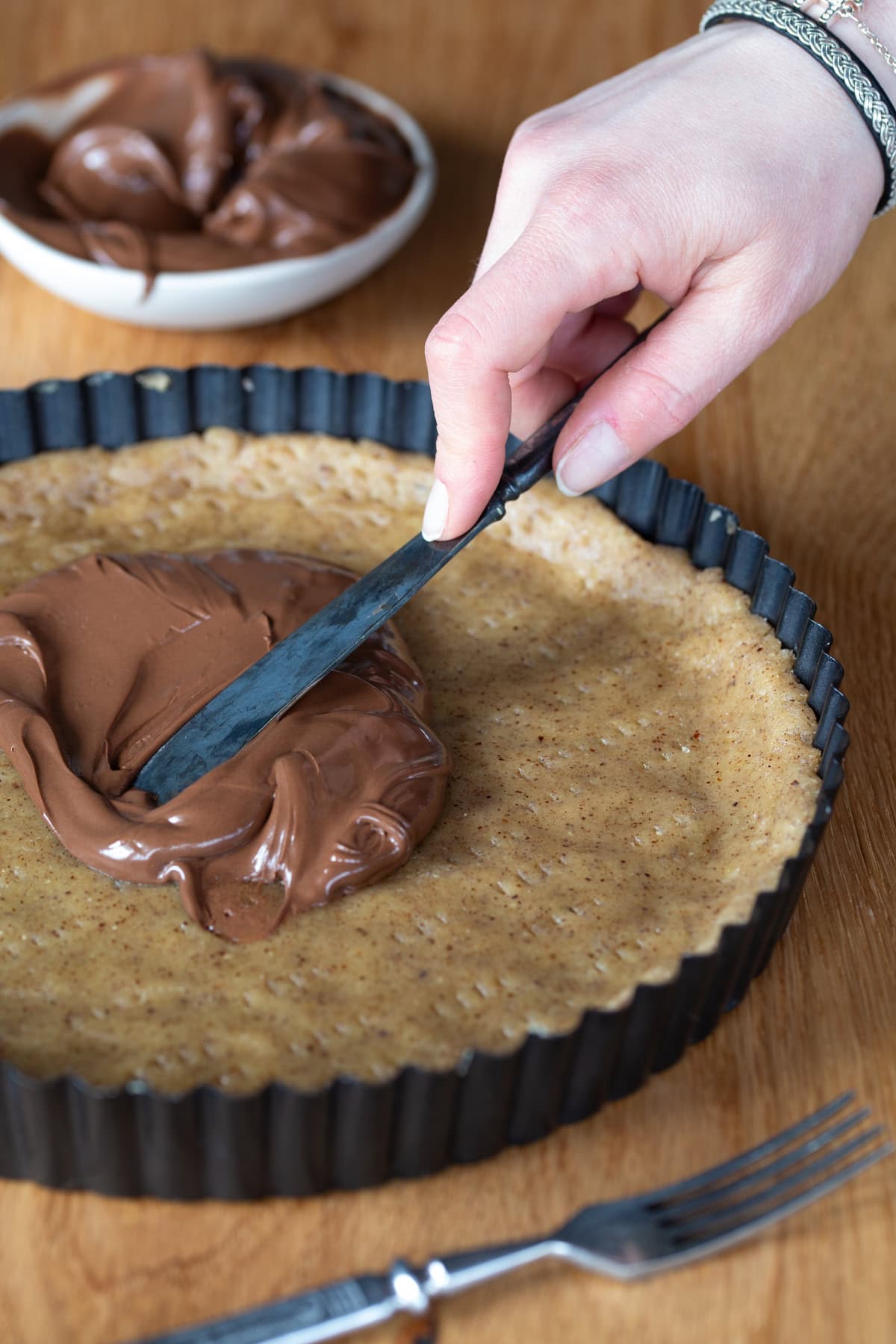 Spreading Nutella over unbaked pie crust.