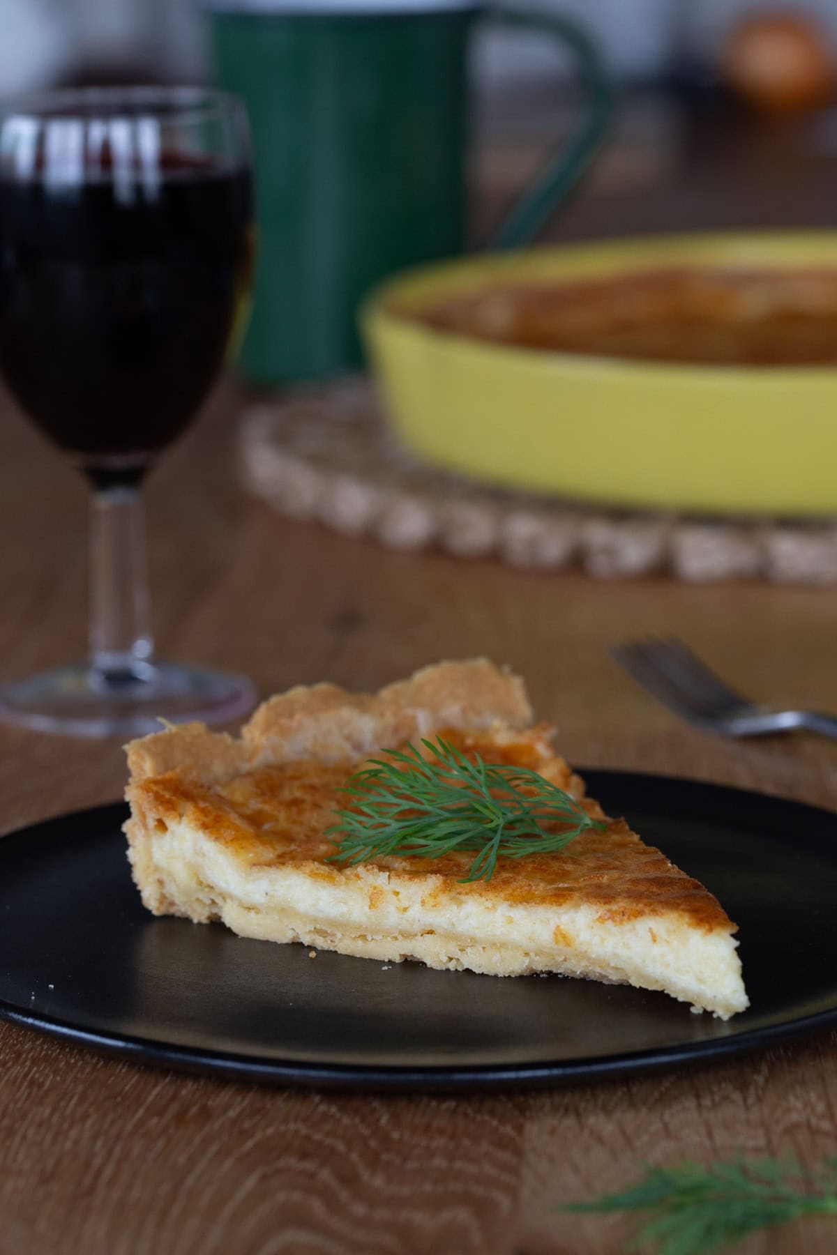 Chhese pie slice with glass of red wine.