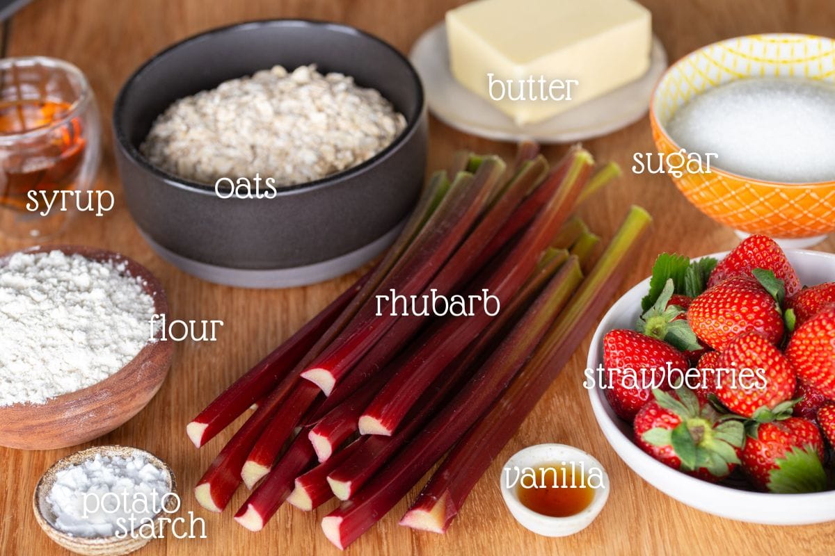 Strawberry rhubarb crisp ingredients on a wooden table.