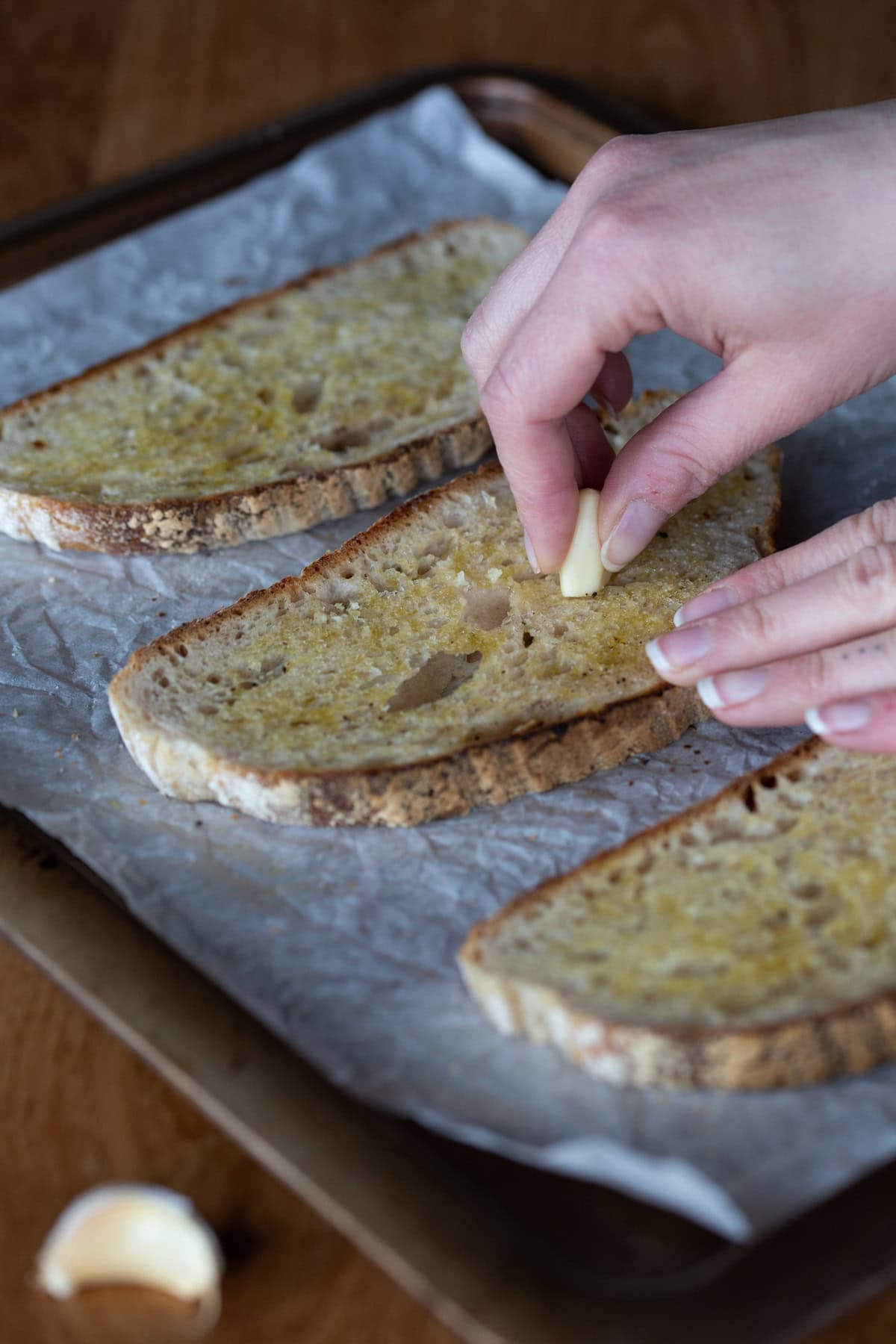 Rubbing garlic clove on toast.