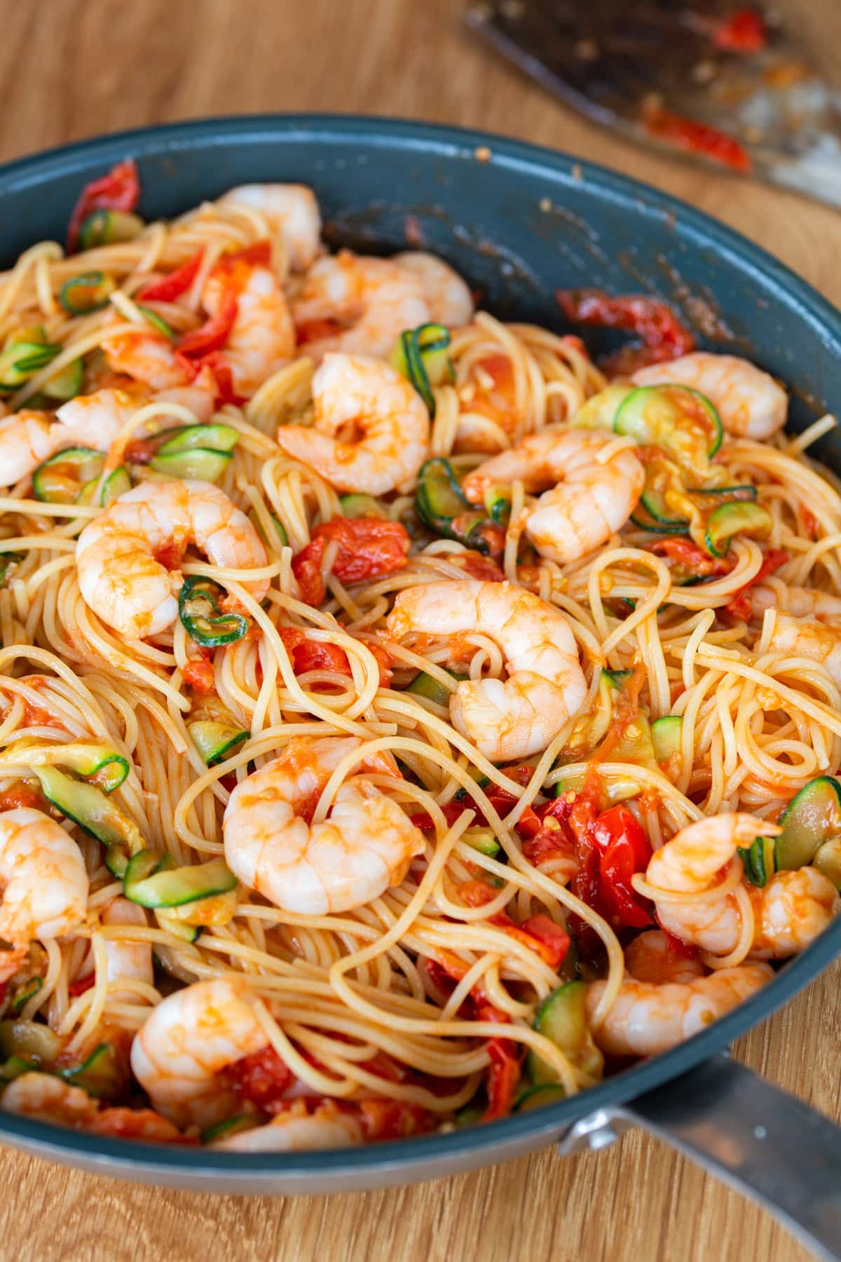 Tossing the pasta in the cherry tomato and shrimp sauce.
