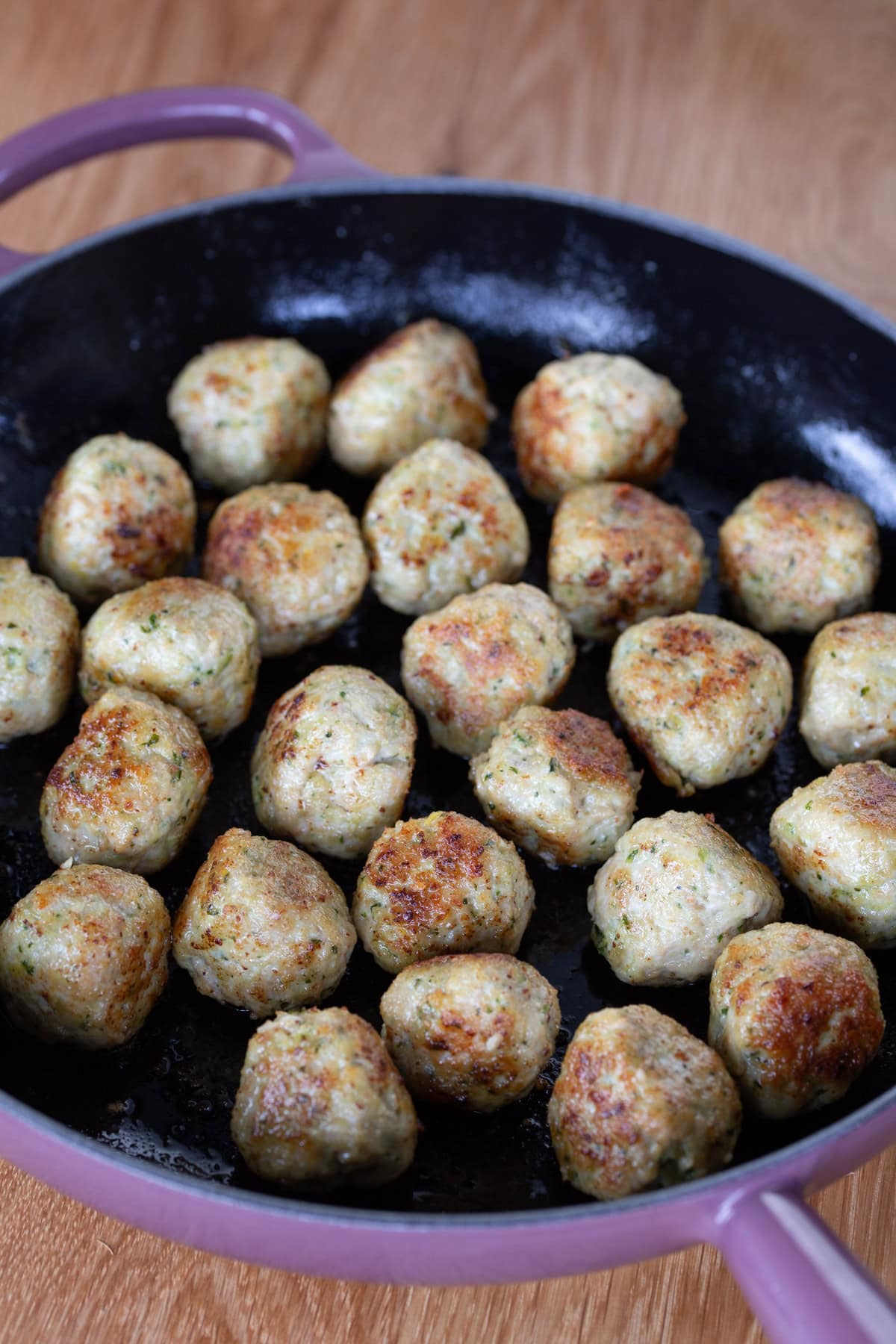Cooking meatballs in a skillet.