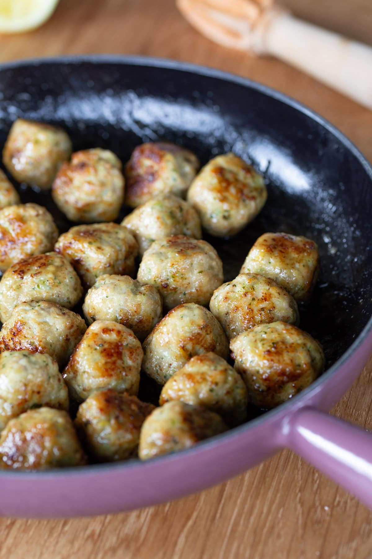 Lemon chicken meatballs in a cast iron skillet.