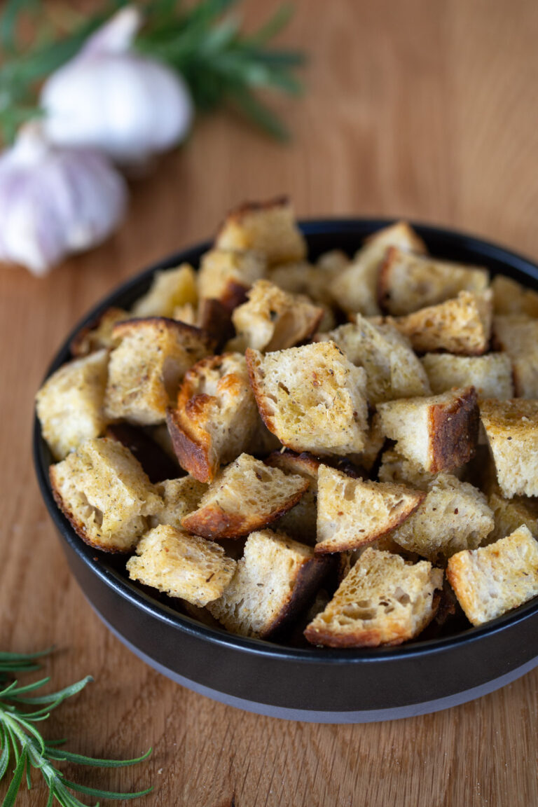 Sourdough bread croutons in a black bowl.