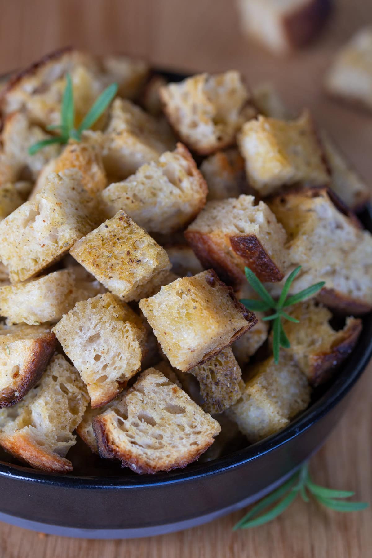 Sourdough bread croutons in a black bowl.