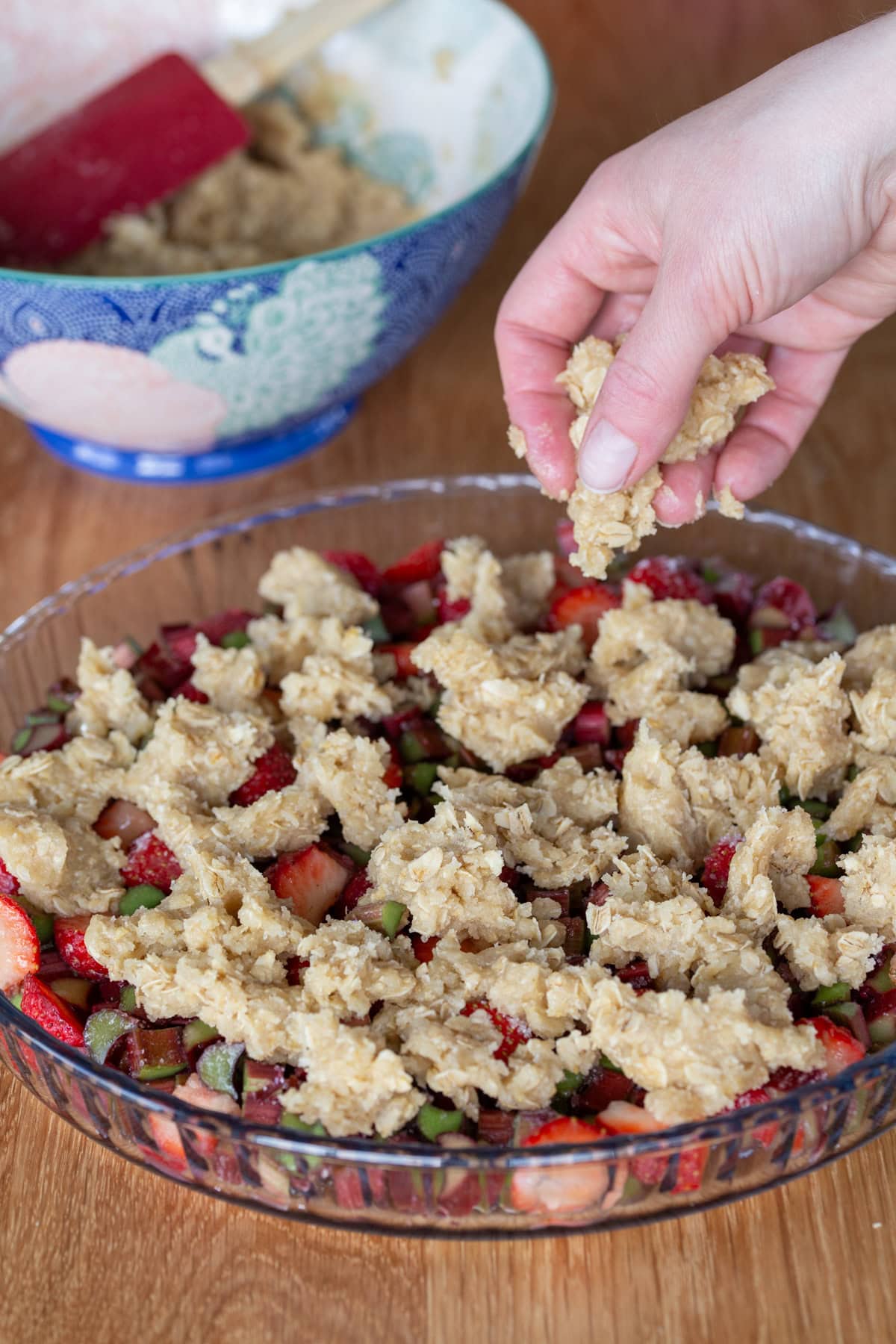 Hand crumbling crisp dough over fruit base.