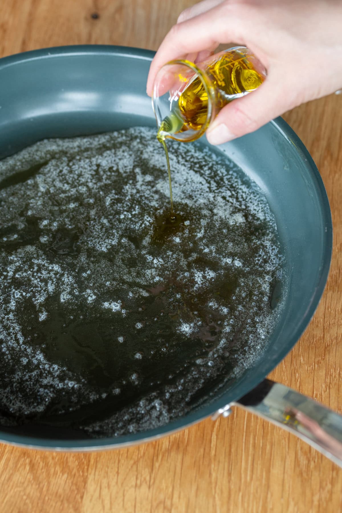 Adding olive oil to a pan with butter.