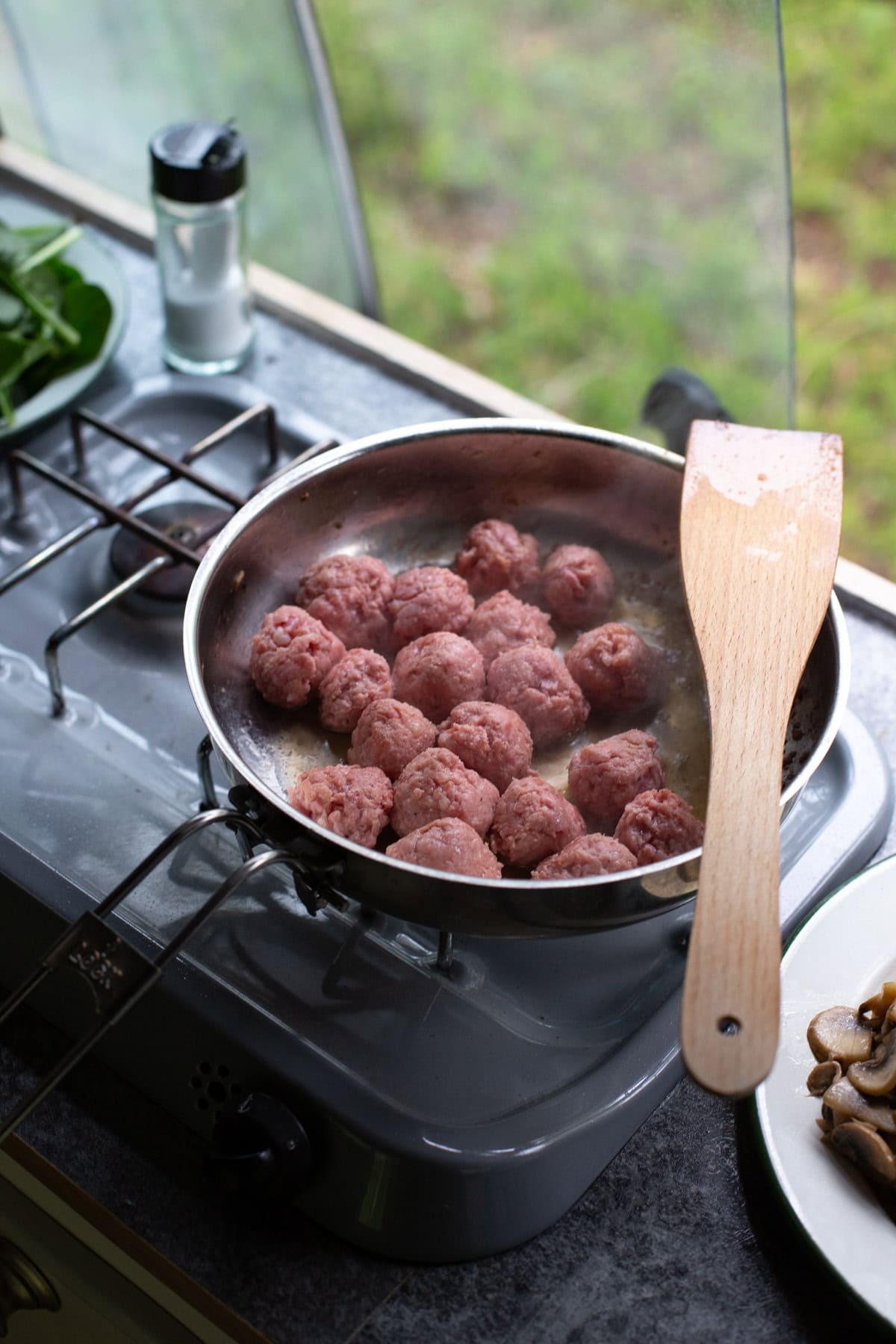 Cooking salsiccia meatballs on a camping stove.