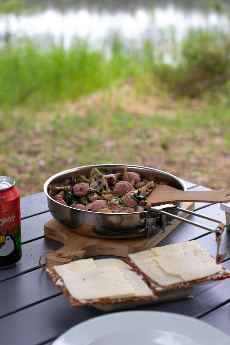 Salsiccia meatballs served with bread and cheese on a camping table.