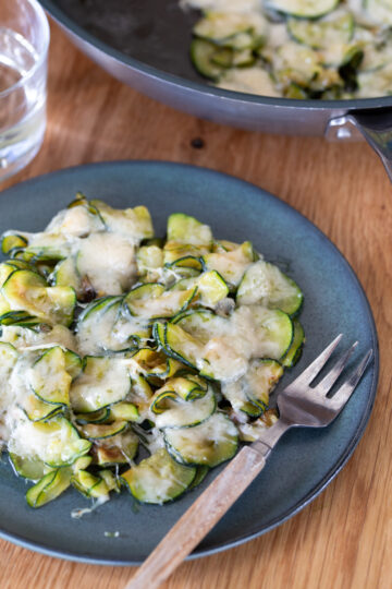 Parmesan zucchini served on a green plate.