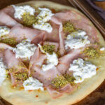 Mortadella pizza with pistachio and burrata closeup.