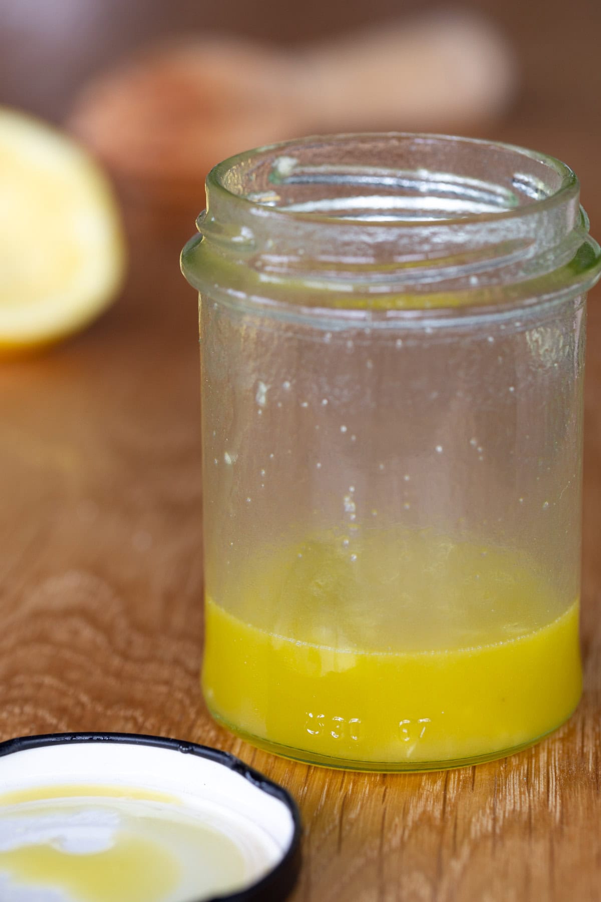 Freshly shaken vinaigrette dressing in a glass jar.