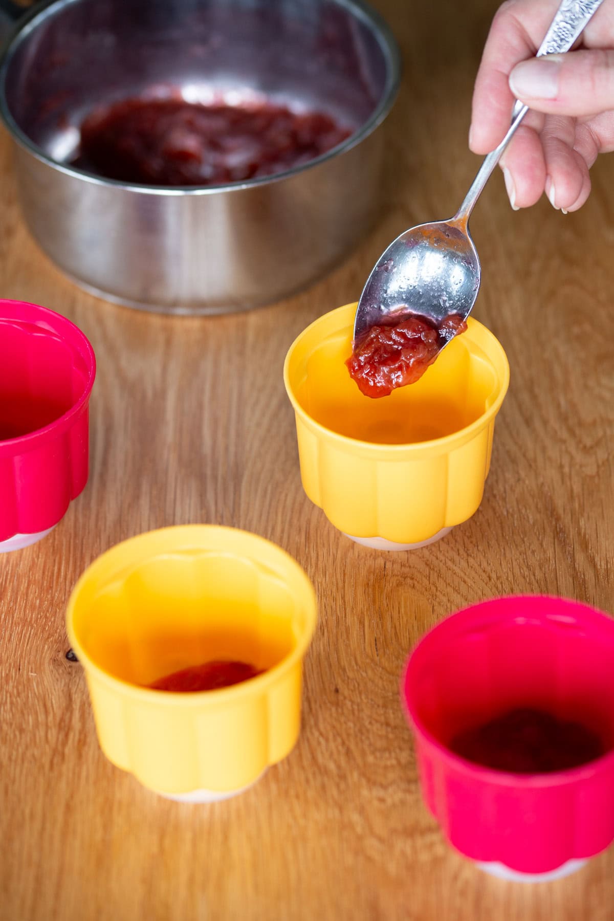 Adding a spoonful of rhubarb compote into molds.