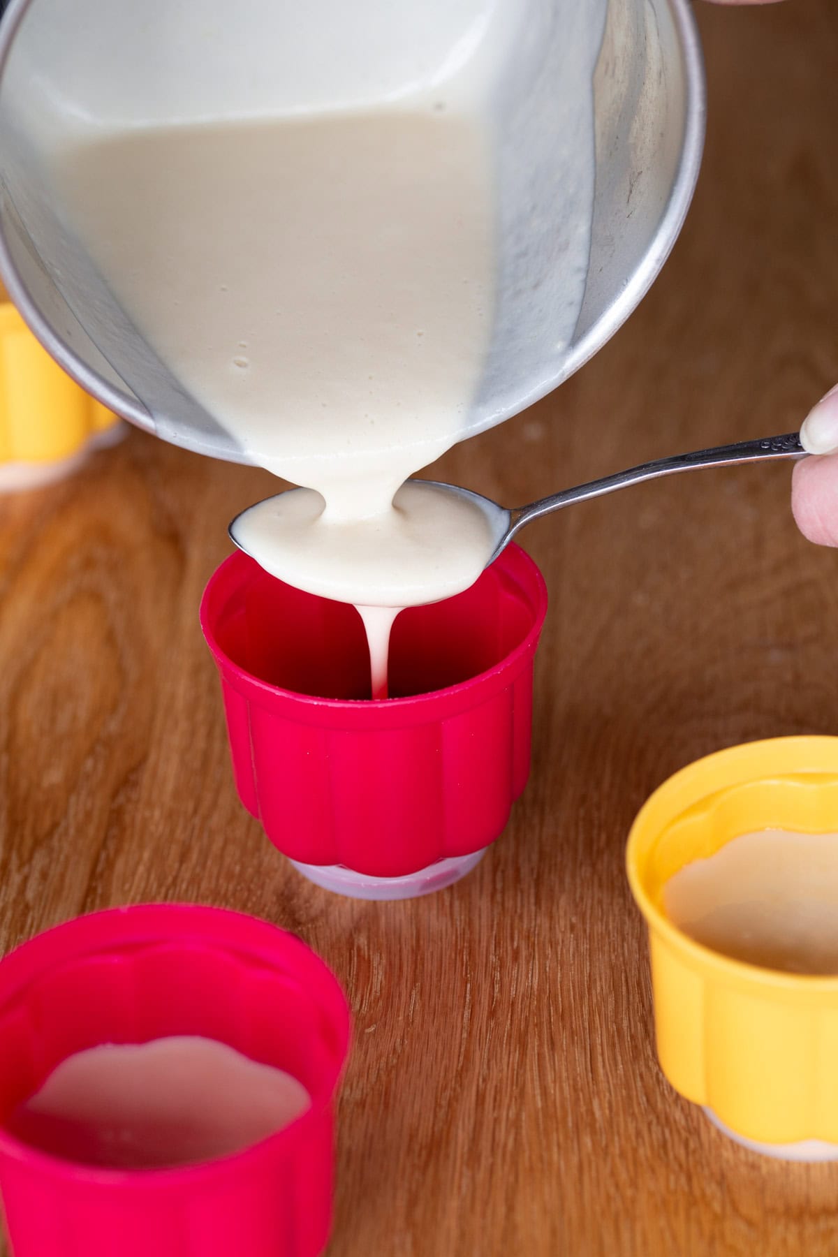 Pouring panna cotta over a spoon.