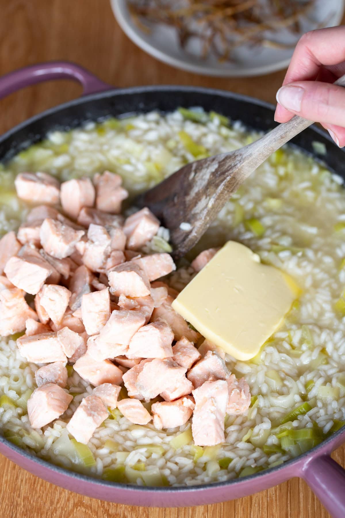 Mixing in butter and cooked salmon into risotto base.