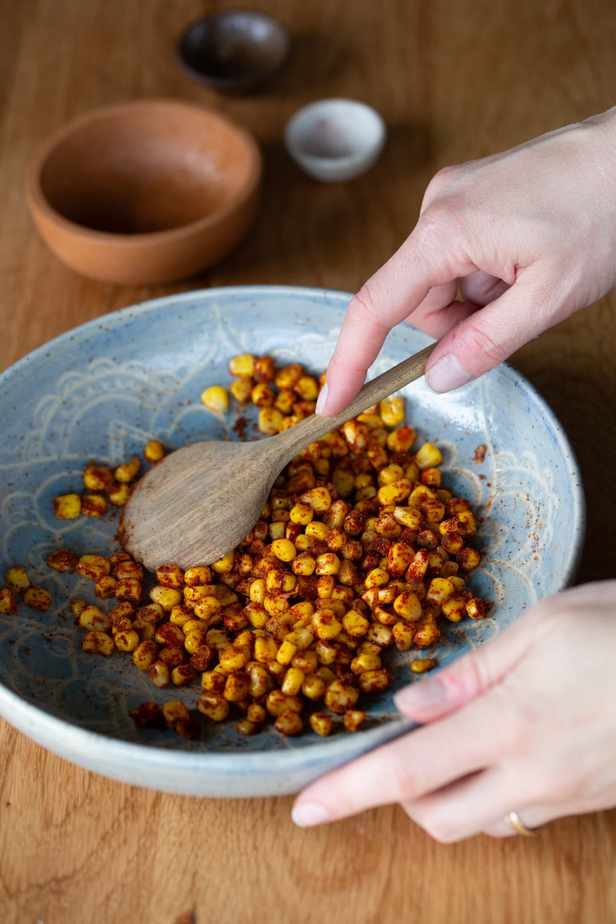 Mixing spices into sweet corn.