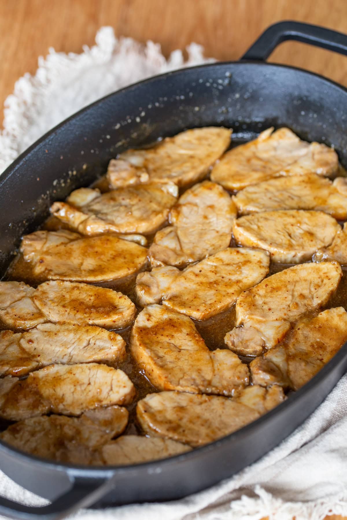 Baked pork loin with mustard and beer glaze in a cast iron casserole dish.