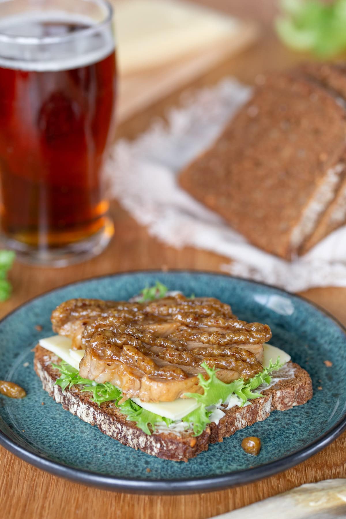 Dark bread sandwich made with baked pork loin with mustard.