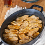 Baked pork loin with mustard and beer glaze in a cast iron casserole dish.
