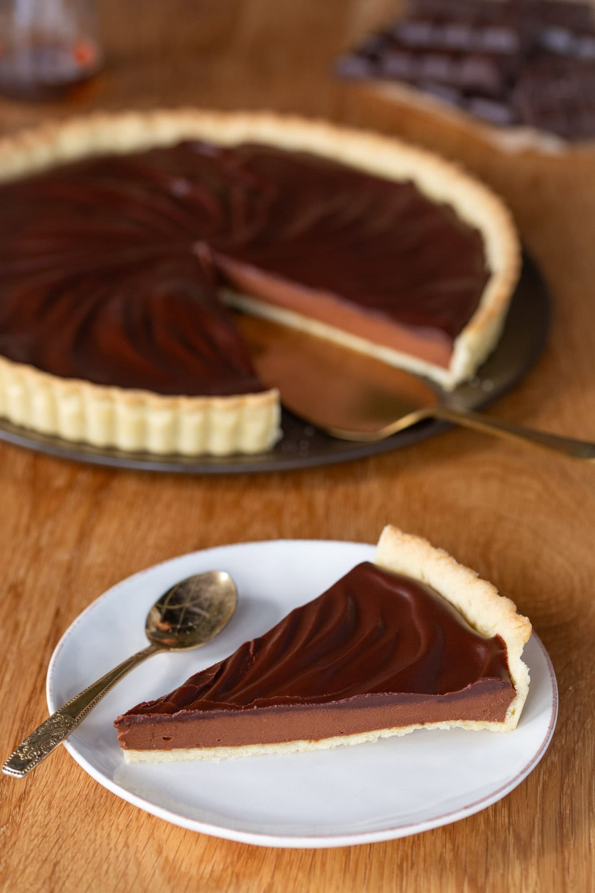 A slice of chocolate sweet potato pie, rest of the pie in the background.