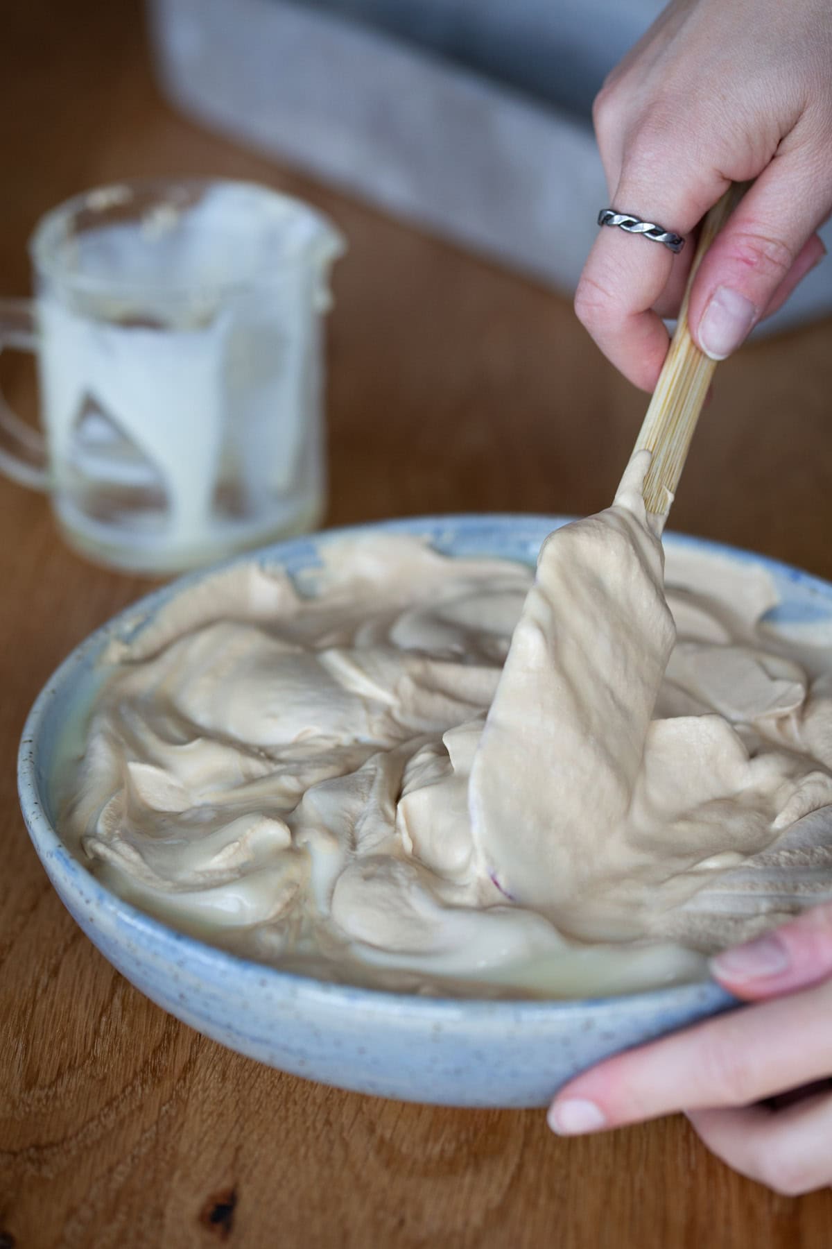 Spatula folding condensed milk into whipped cream.