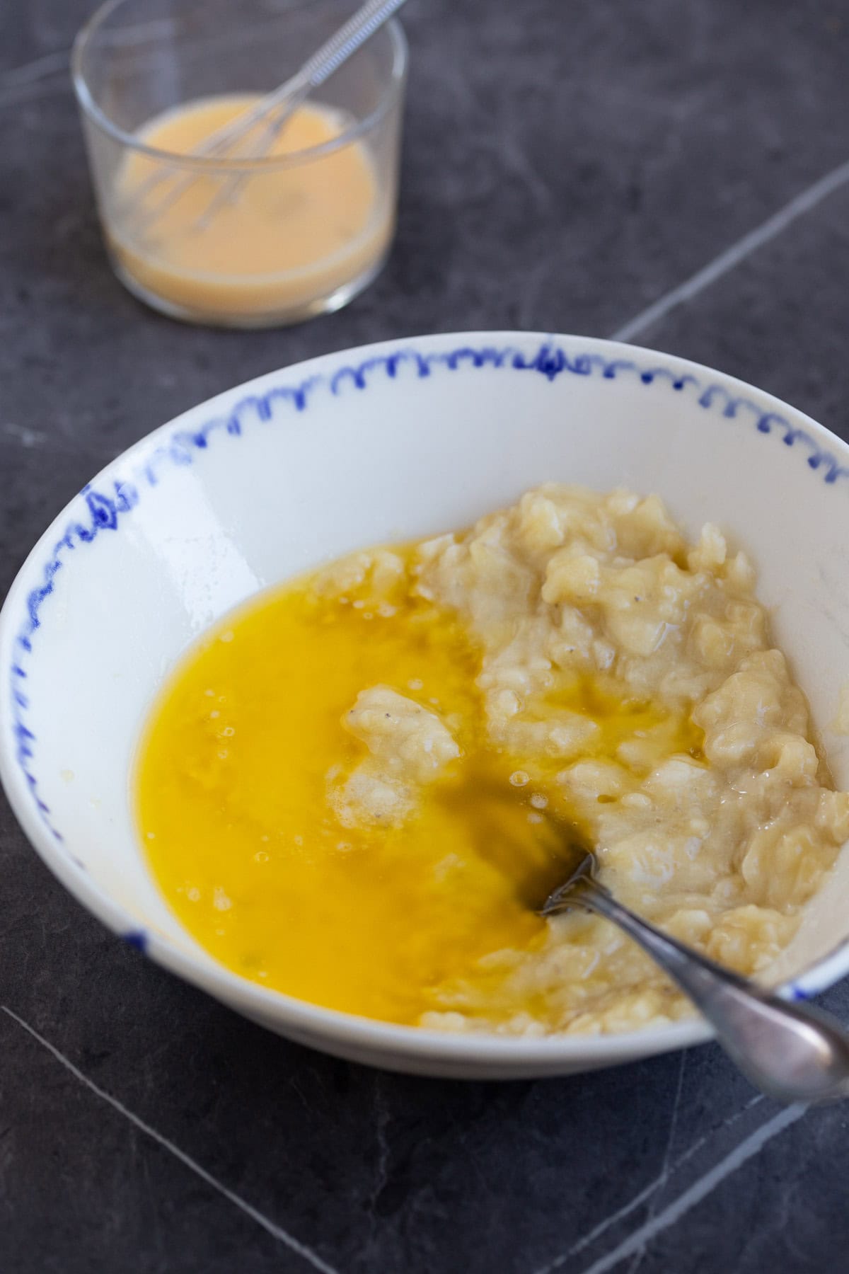 Mashed banana and melted butter in a bowl.