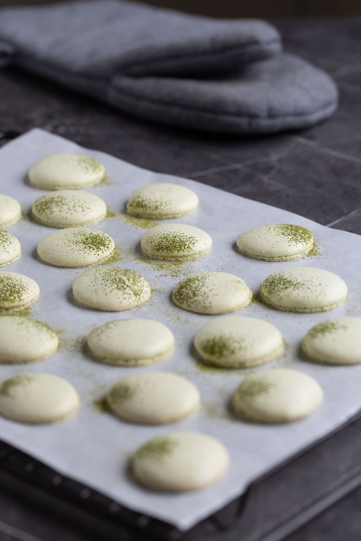 Baked macarons cooling on a rack.