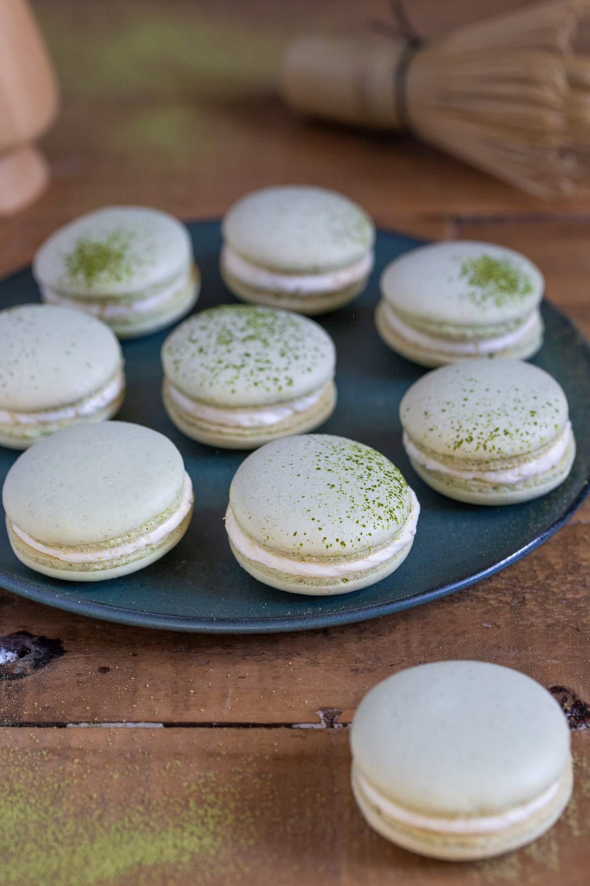 Matcha macarons served on a green plate.
