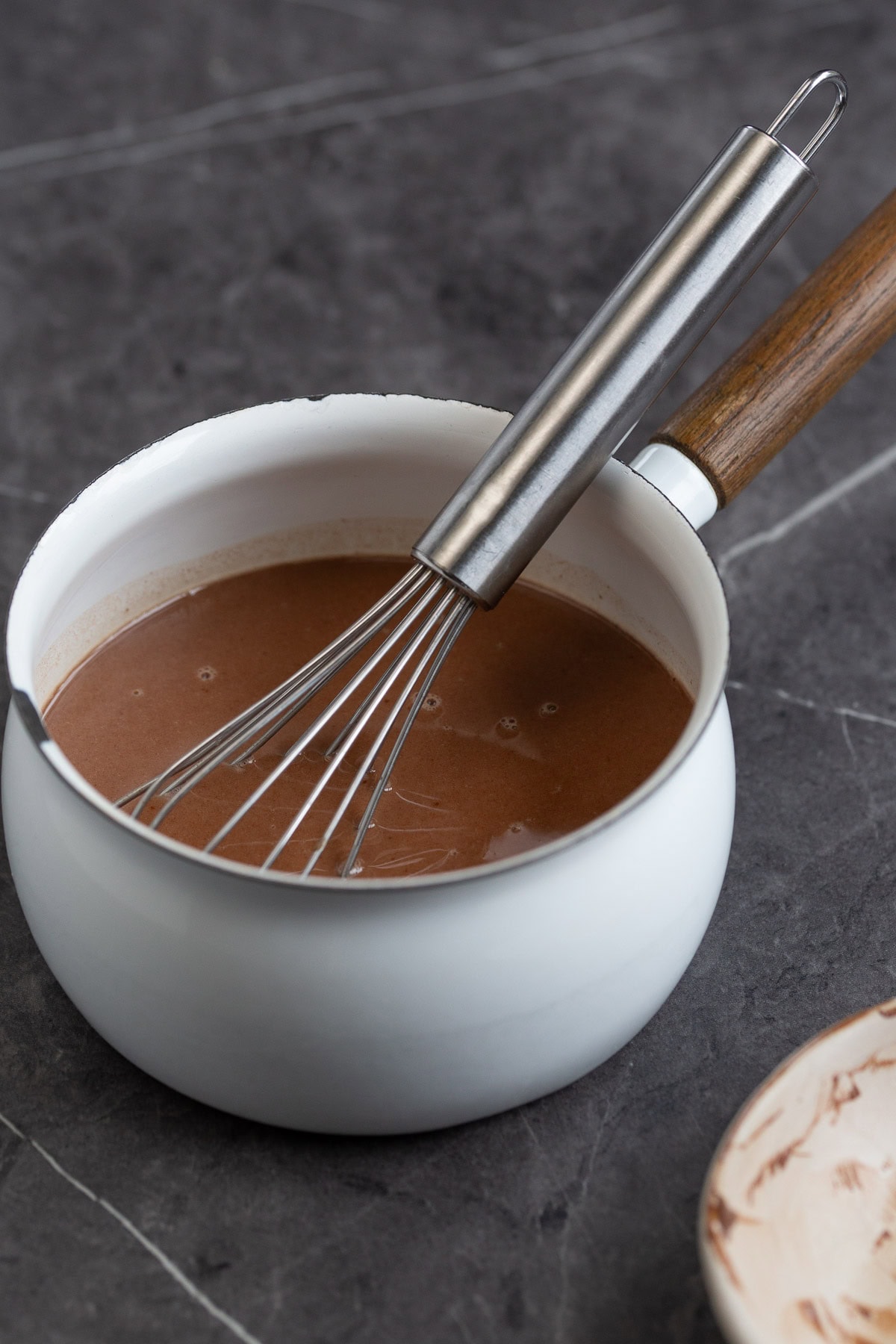 A small saucepan with warm panna cotta inside.