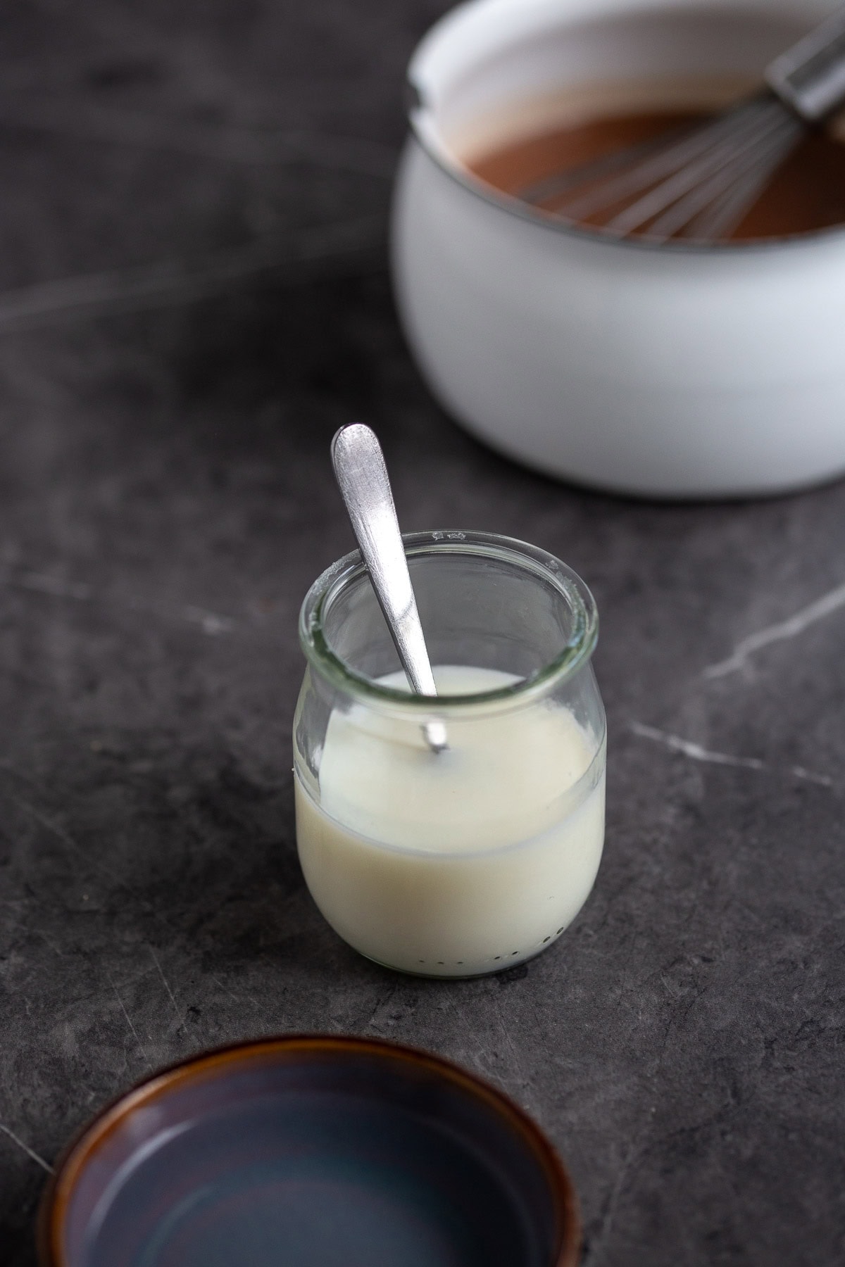 Small glass container containing milk.