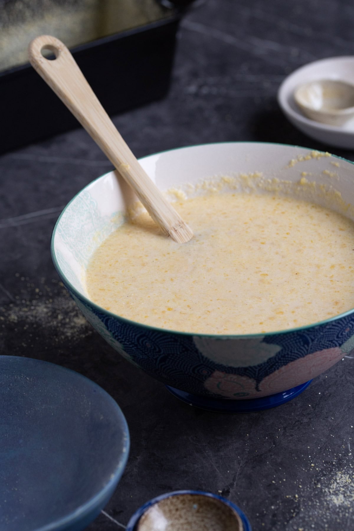 Cornbread batter in a bowl with a spatula inside.